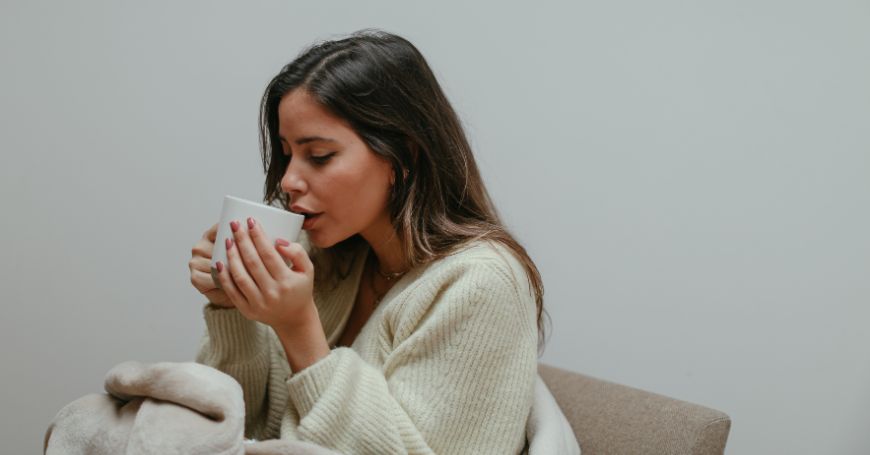 mujer bebiendo una infusión remedio natural para el ciclo